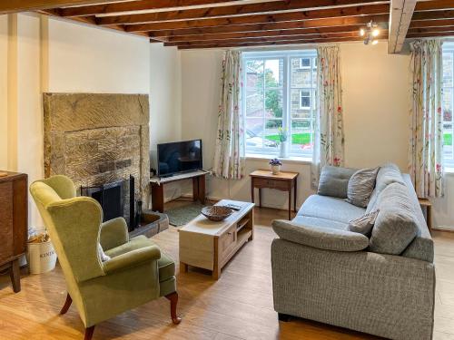 a living room with a couch and a fireplace at Jennys Cottage in Osmotherley