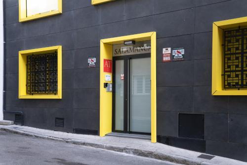 a building with a yellow door on the side of it at Bernabéu Business & Stay in Madrid