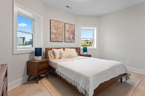 a white bedroom with a bed and two windows at Lux 2BD Apartment in Dupont Circle Washington DC in Washington