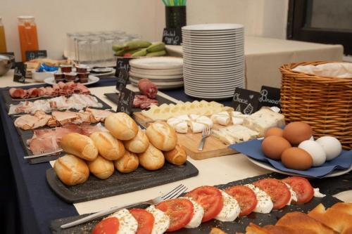 a table topped with plates of food and eggs and bread at Hotel Torre Orefici in Genova