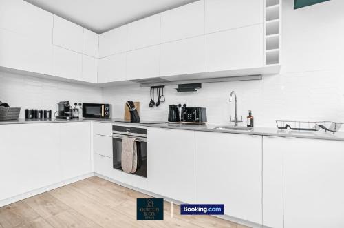 a white kitchen with white cabinets and appliances at Luxury 3BDR Flat - Short Lets & Serviced Accommodation Wembley With Wi-Fi, Gym & Cinema in London