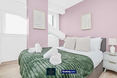 a bedroom with a bed with two towels on it at Luxury 3BDR Flat - Short Lets & Serviced Accommodation Wembley With Wi-Fi, Gym & Cinema in London