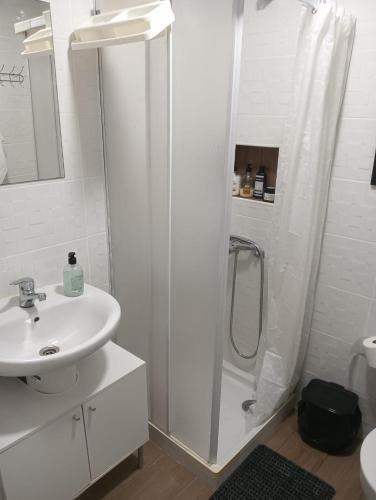 a white bathroom with a shower and a sink at Loft Ohanes in Ohanes