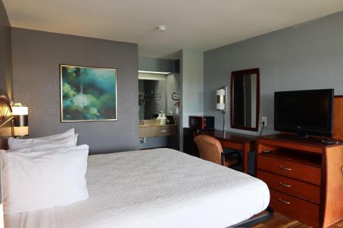 a hotel room with a bed and a flat screen tv at Americas Best Value Inn Yukon in Yukon