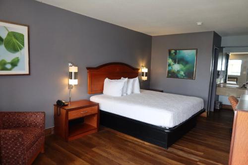 a hotel room with a bed and a couch at Americas Best Value Inn Yukon in Yukon