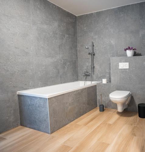 a bathroom with a bath tub and a toilet at Vila Linet in Poprad