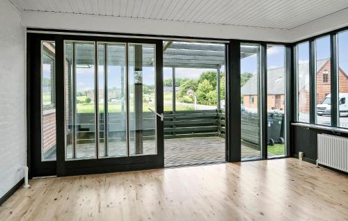 an empty room with glass doors and a wooden floor at 1 Bedroom Nice Home In Hurup Thy in Ullerup