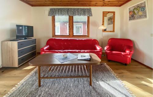 a living room with a red couch and a table at Stunning Home In Byxelkrok With Wifi in Byxelkrok