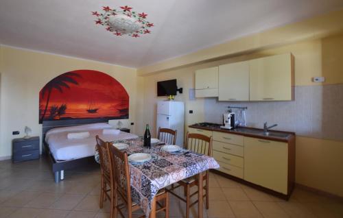 eine Küche mit einem Tisch und ein Zimmer mit einem Bett in der Unterkunft Amazing Apartment In Ricadi in San Nicolò