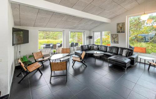 a living room with a couch and tables and chairs at Nice Home In Blåvand With Sauna in Blåvand