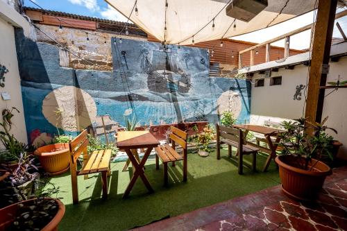 アンティグア・グアテマラにあるAmura Hostel - Antigua Guatemalaのパティオ(テーブル、椅子、壁画付)