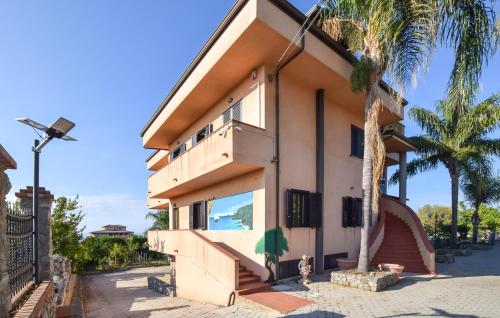 ein Gebäude mit einer Palme davor in der Unterkunft Nice Apartment In Ricadi With Wifi in San Nicolò