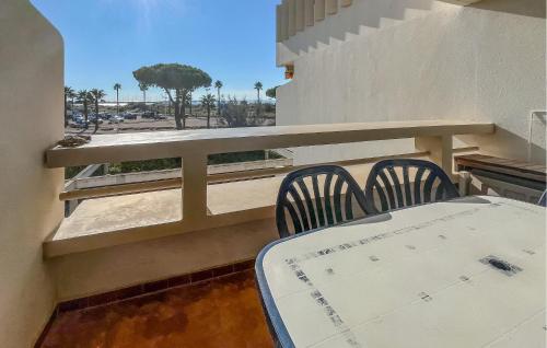 a balcony with two chairs and a table on a building at Beautiful Apartment In Le Grau-Du-Roi With Wifi in Le Grau-du-Roi