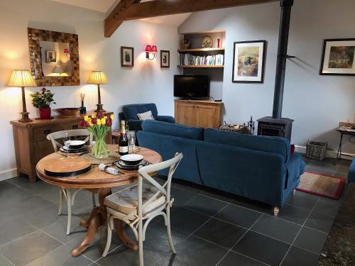 a living room with a blue couch and a table at The Barn, Llanerch Y Felin in Rowen