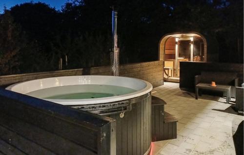 a large bath tub sitting on a patio at night at Amazing Home In Glesborg With Sauna in Fjellerup Strand
