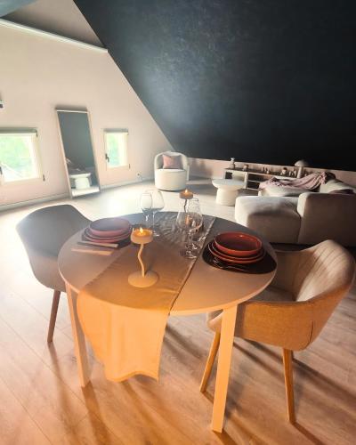 un salon avec une table et un canapé dans l'établissement LOVEROOM - Le pavillon des arômes, à Aiserey