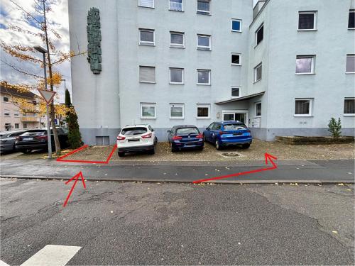 two cars parked in a parking lot in front of a building at NEW! StayPfalz Apartment - 3 Zimmer & Parkplatz in Neustadt an der Weinstraße