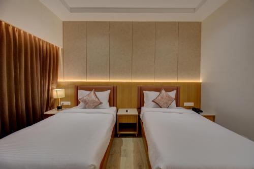 two beds in a hotel room with two beds sidx sidx sidx at Hotel Warma Palace in Yeola
