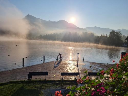 una vista di un lago con panchine di fronte di by franz a Kirchberg in Tirol