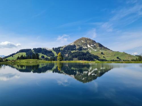 una montagna che si riflette su un lago con il suo riflesso di by franz a Kirchberg in Tirol