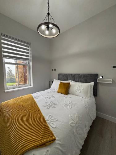 a bedroom with a bed with a yellow blanket on it at The Waterboard House in Magherasaul