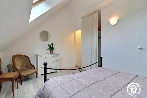 1 dormitorio con cama, silla y vestidor en Hoedic, en Surzur
