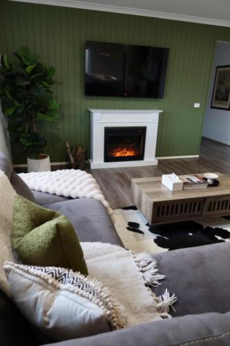 a living room with a couch and a fireplace at The Nagambie Stay in Nagambie