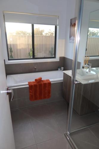 a bathroom with a bath tub and a sink at The Nagambie Stay in Nagambie