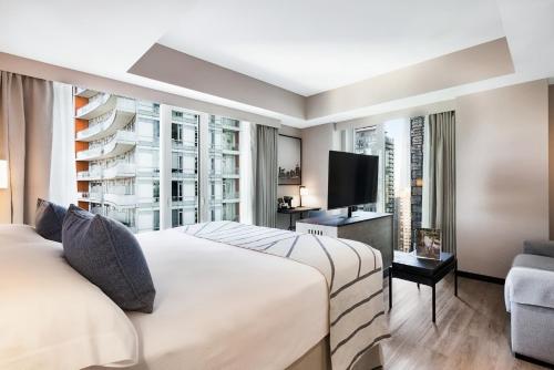 a hotel room with two beds and a tv at Riu Plaza Toronto in Toronto