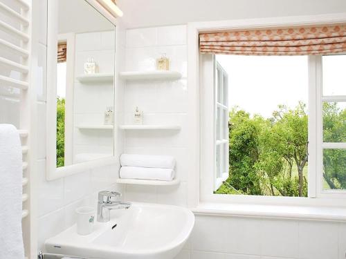 une salle de bain blanche avec un lavabo et une fenêtre dans l'établissement Drosselhues-Sued, à Kampen