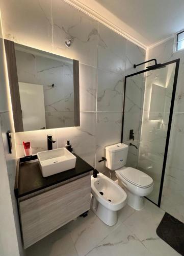 a bathroom with a toilet and a sink and a mirror at Calma 1939 in Villa Carlos Paz