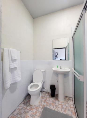 a white bathroom with a toilet and a sink at Hotel Sweet Dreams in La Unión