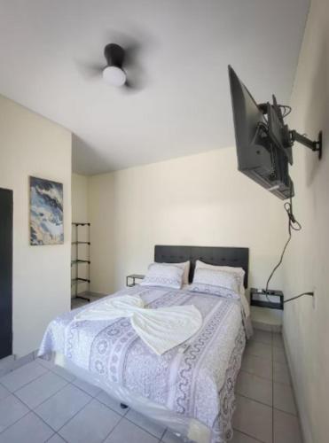 a bedroom with a bed and a tv on the wall at Hotel Sweet Dreams in La Unión
