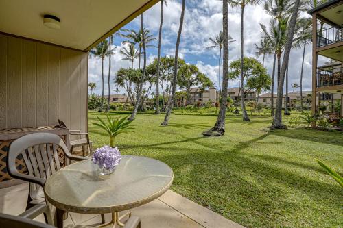 une table et des chaises sur une terrasse avec des palmiers dans l'établissement Pono Kai Resort J101, à Kapaa