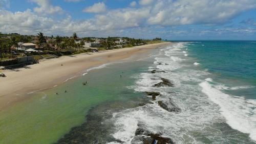an aerial view of a beach with people in the water at Casa dos Corais in Cabo de Santo Agostinho