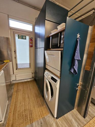 a kitchen with a washer and dryer in a trailer at Loft style big studio for 2-4 in Pikku Huopalahti in Helsinki