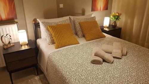 a bedroom with a bed with yellow pillows and two lamps at Ntarmos Apartment in Sparti
