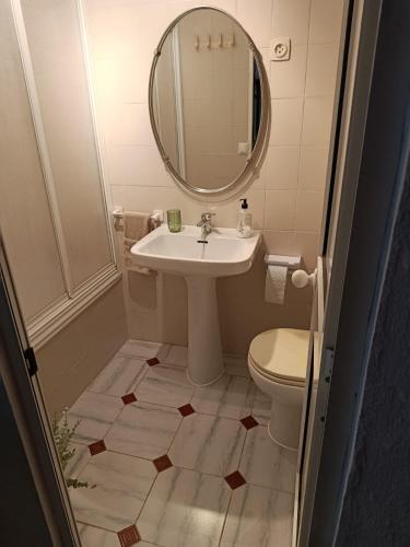 ein Badezimmer mit Waschbecken, Spiegel und Toilette in der Unterkunft La Casita in El Real de la Jara