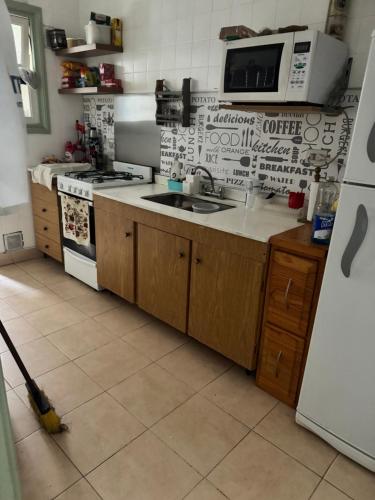 a kitchen with a sink and a stove top oven at Departamento al mar in Miramar