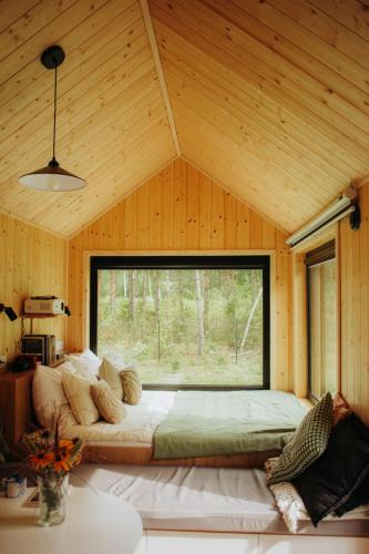 a bed in a room with a large window at Ten Mały Domek in Ciwoniuki