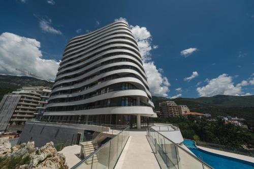 un grand bâtiment avec une piscine en face dans l'établissement La barca apartments, à Becici