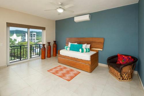 a bedroom with a bed and a chair and a window at Gorgeous Penthouse across from Beach with Ocean Views! in Punta Mita