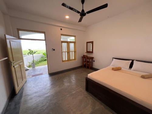 um quarto com uma cama e um ventilador de teto em The Sunset Weligama em Weligama