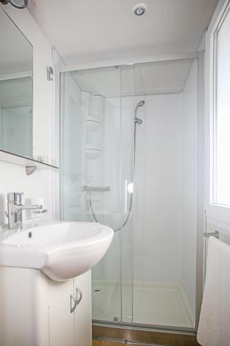 a bathroom with a sink and a glass shower at Auto-kamp Dvije suze 2 in Brištane