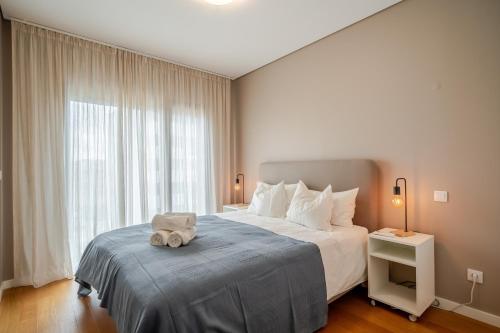 une chambre avec un lit avec un animal en peluche dessus dans l'établissement HolidaysPT - Sunset At Lux Terrace - 2 Bedroom Apt, à Faro