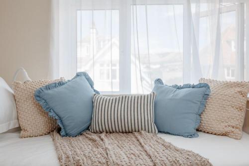 eine Gruppe von Kissen auf einem Bett in einem Zimmer in der Unterkunft Sea Breeze in Ulwell