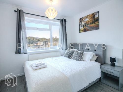 ein Schlafzimmer mit einem weißen Bett und einem Fenster in der Unterkunft Bright 2BR Terrace in Basildon, Garden and Amenities in Basildon