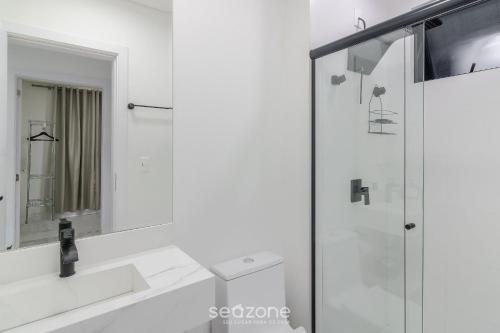 a bathroom with a shower and a sink and a mirror at Estadia completa a 500m do mar em Itapema - STWs in Meia Praia