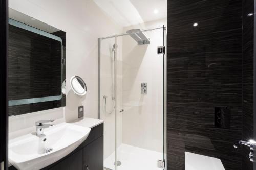 a bathroom with a sink and a shower at The Westbourne Hyde Park in London