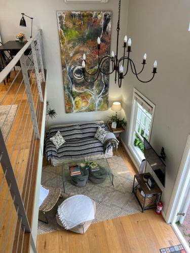 een woonkamer met een bank en een schilderij aan de muur bij Magnolia Cottage in Kaapstad